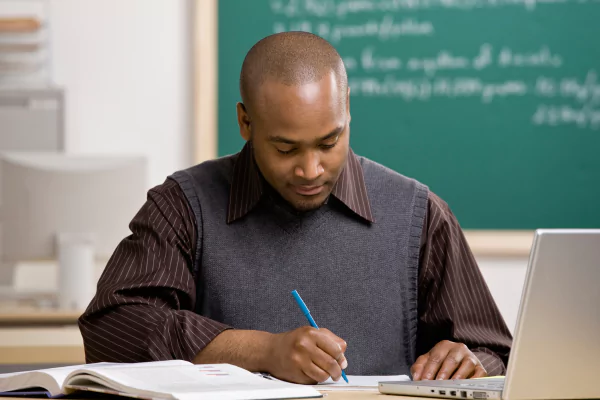 A math teacher is reading MATHia data reports on his computer to gather data about future assessment performance