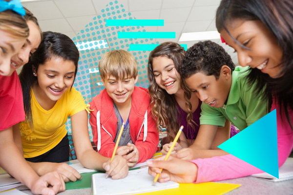 A picture of middle-school aged students talking in a classroom. They are writing in notebooks.