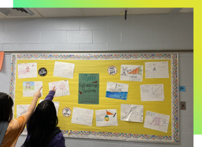 Students point to work they are proud of from Ms. Freund's middle school math class. 